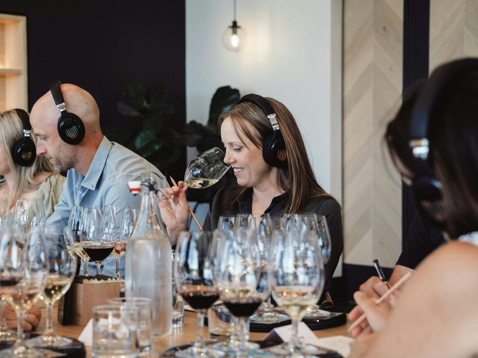 Guest smelling the wine while listening to the music through a headphone