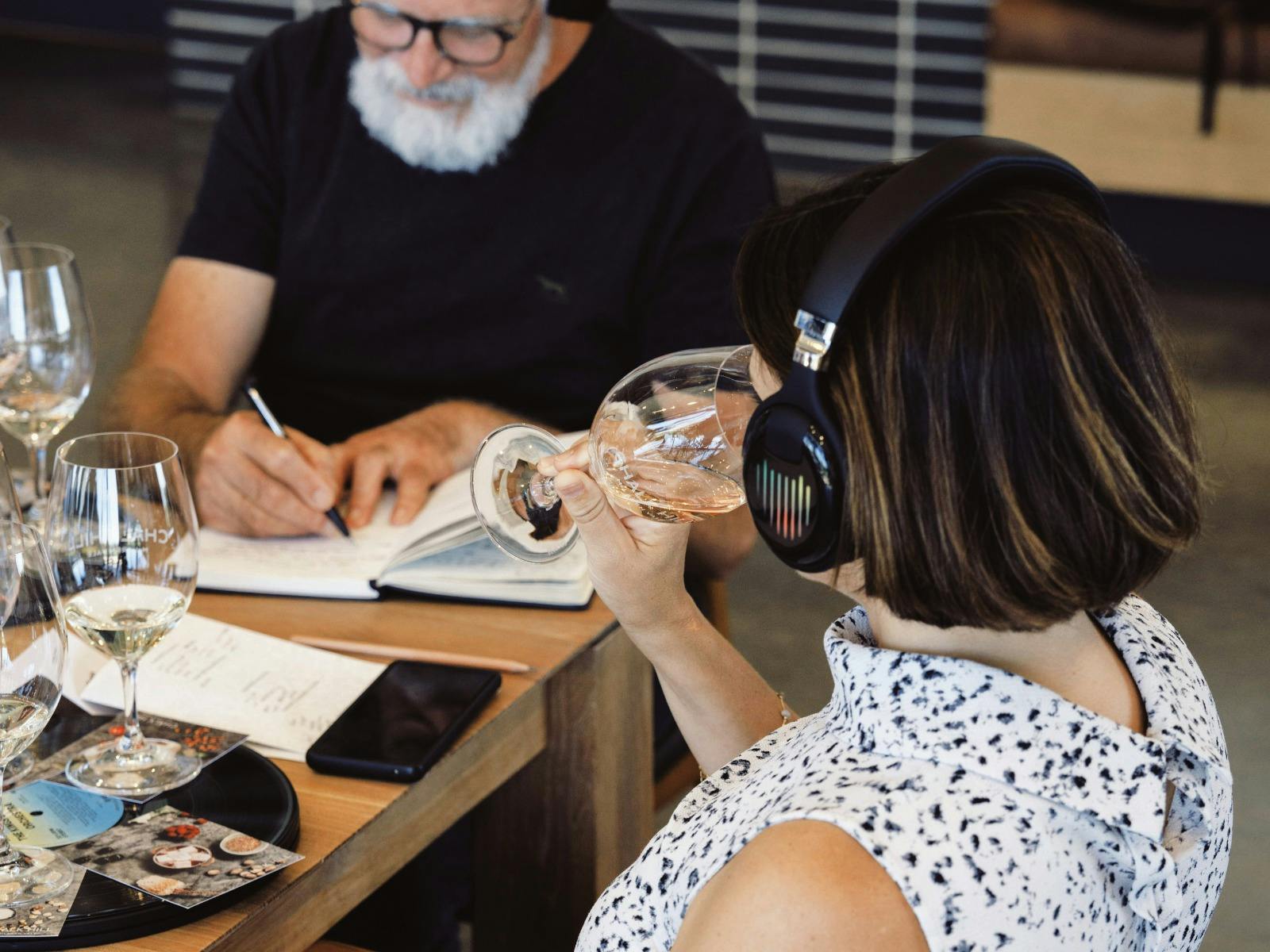 Guest smelling the wine while listening to the music through a headphone