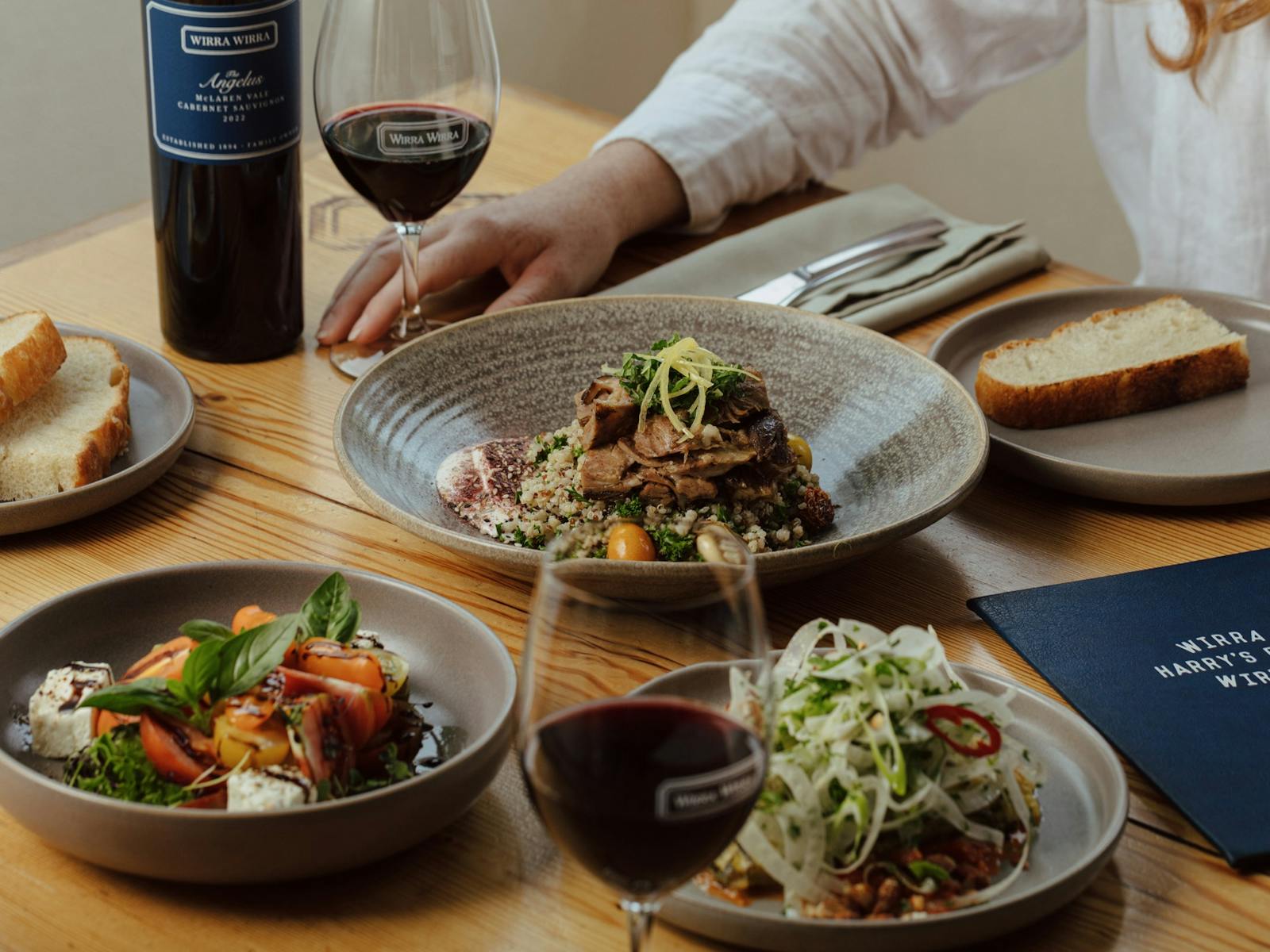 A table with shared plates and glasses of Wirra Wirra wine
