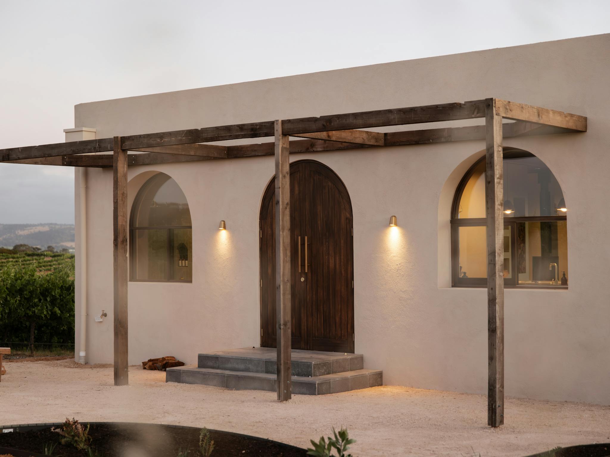 A private courtyard on entrance features a fireplace and reclaimed timber dining setting.