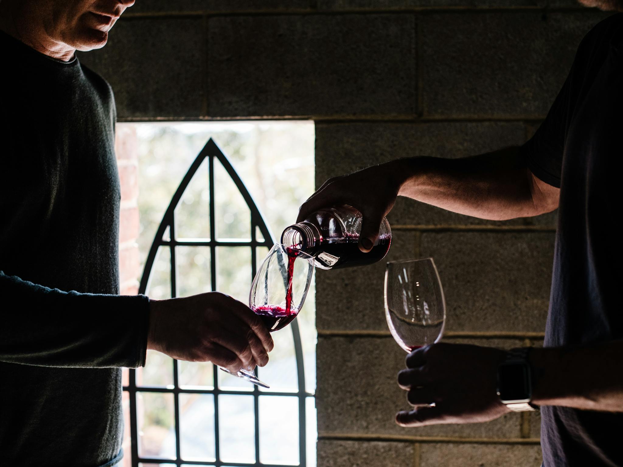 A winemaker pours a glass of wine during a winery tour at Chapel Hill