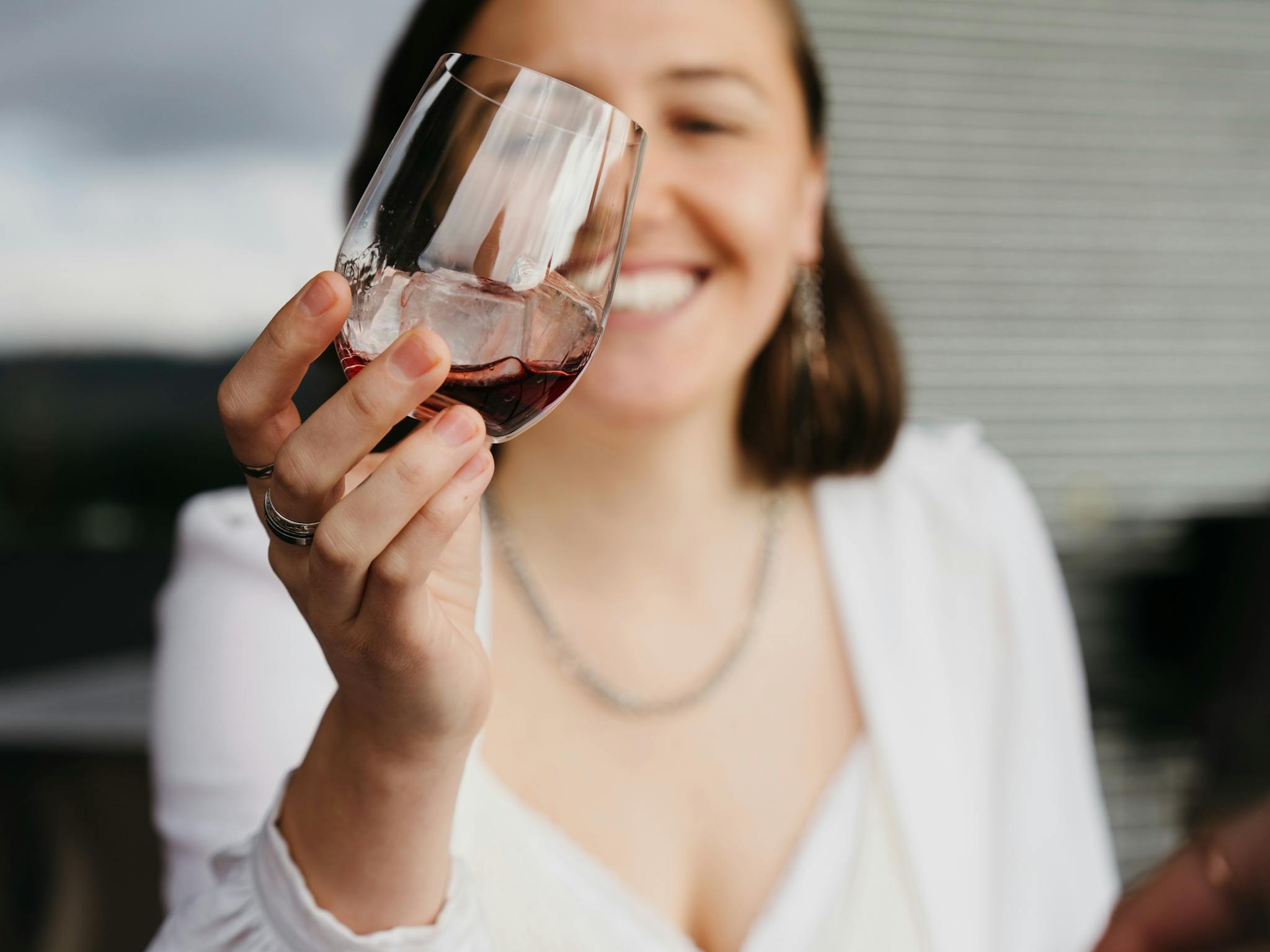 Woman enjoying a drink from a tasting glass at a table