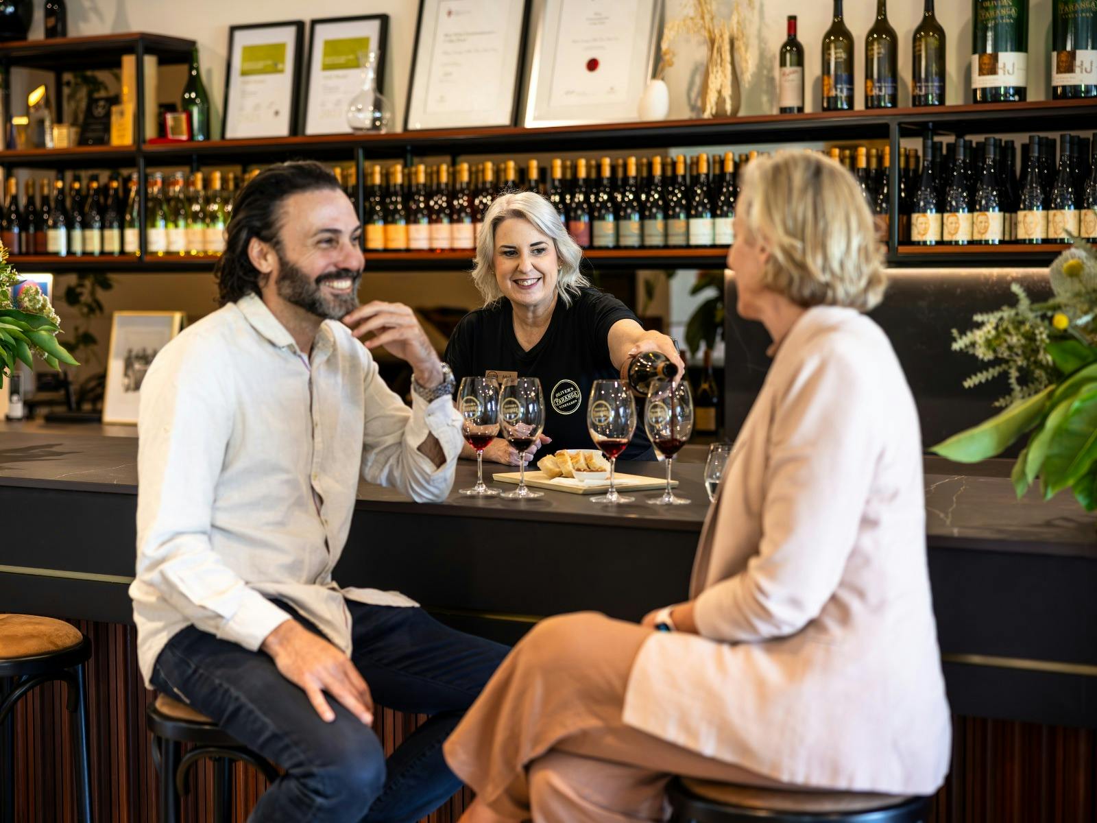 A couple seated at a wine bar with glass
