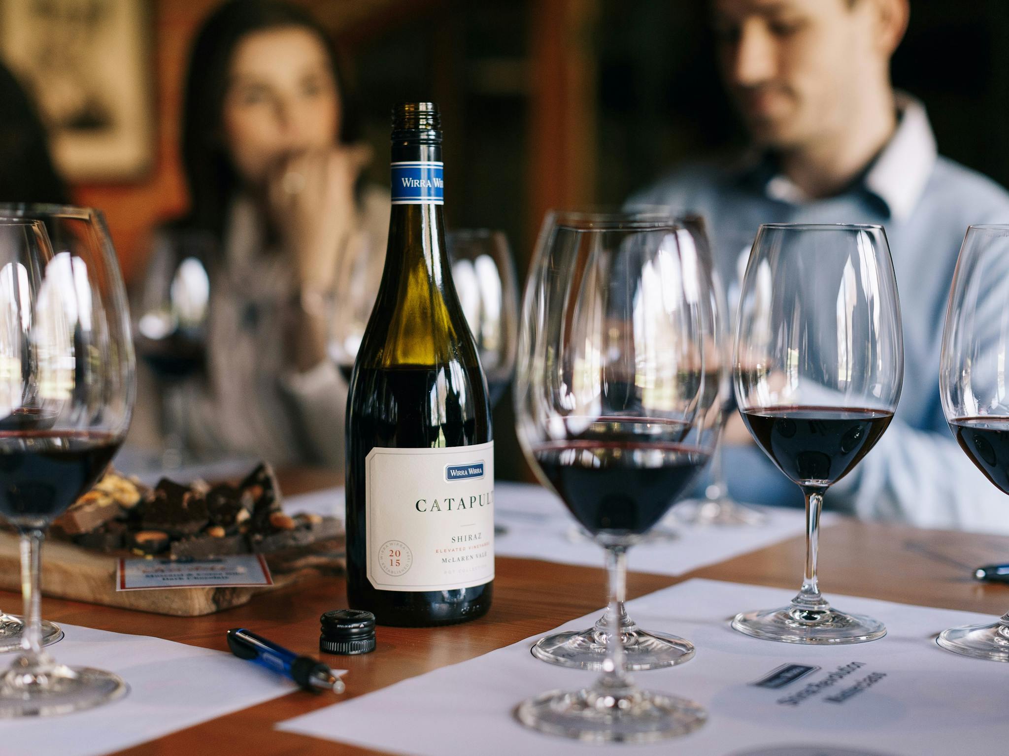 Glasses are laid out for a wine tasting with tasting mats.