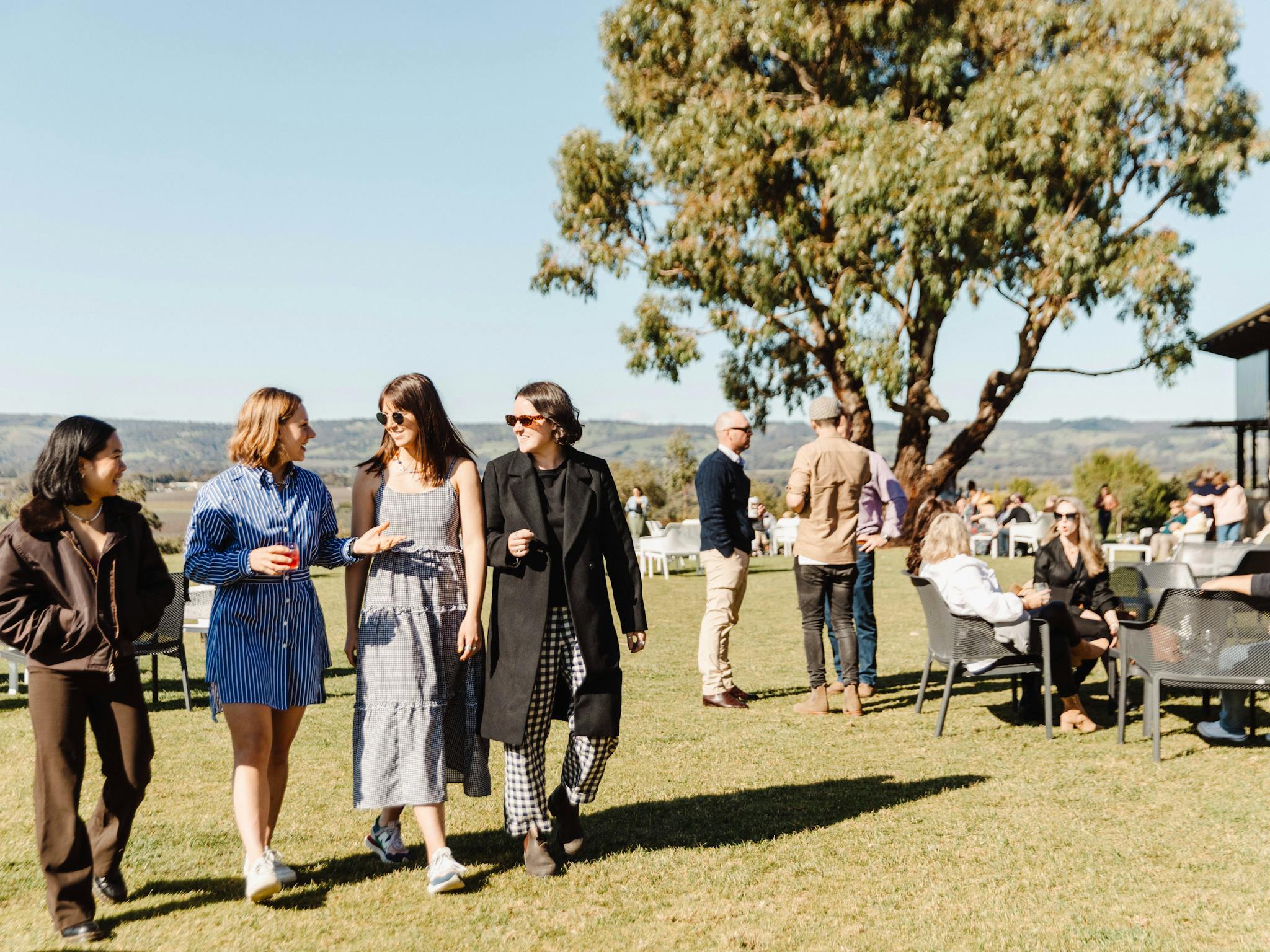 group of women walking on lawn with gin in hand