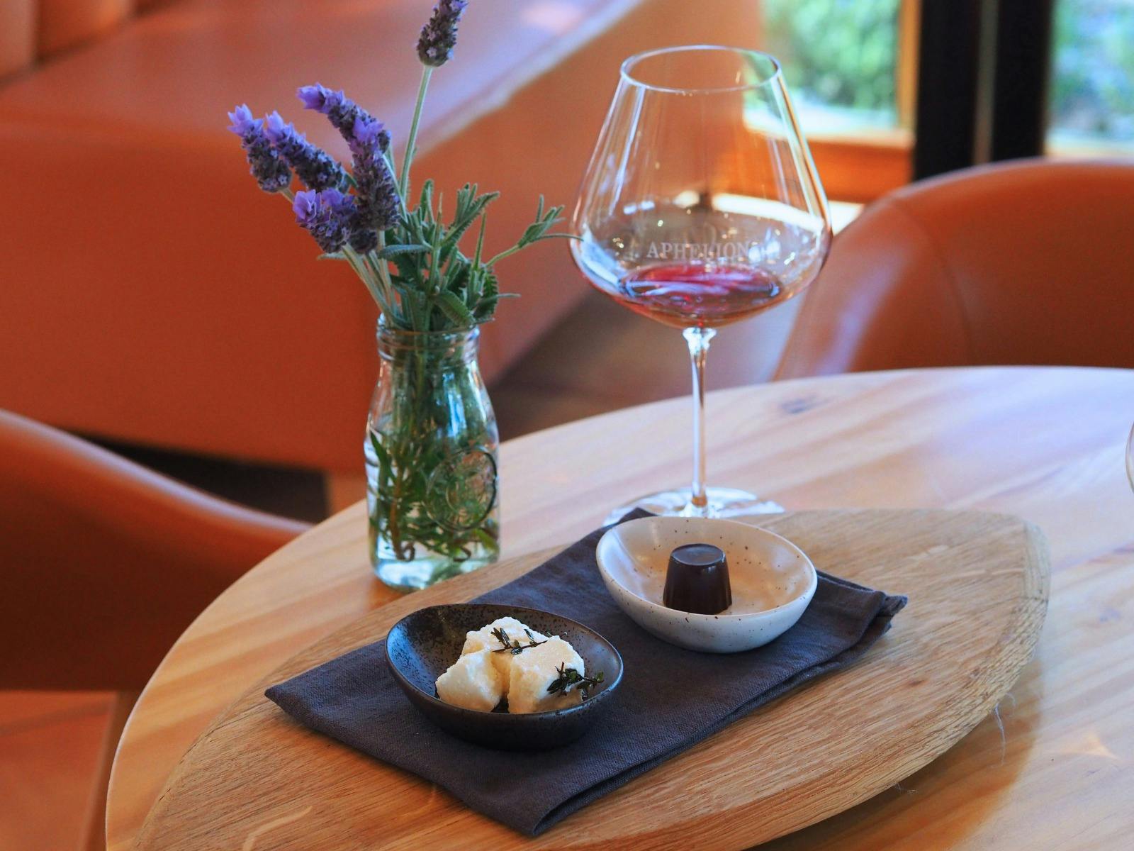 Aphelion Callow Grenache Blanc in a glass with a chocolate and some feta cheese