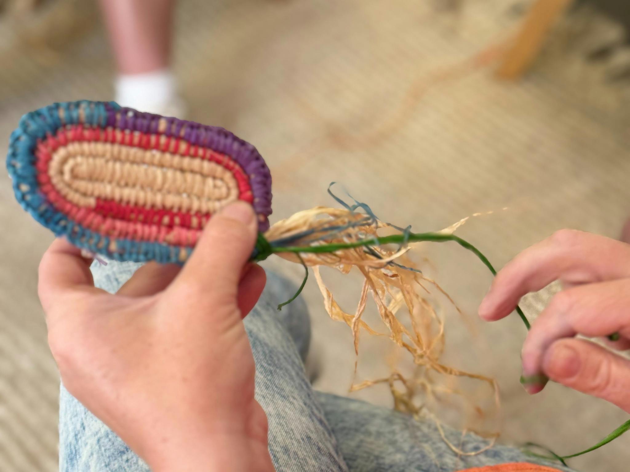 2 hands holding a needle and threading a basket
