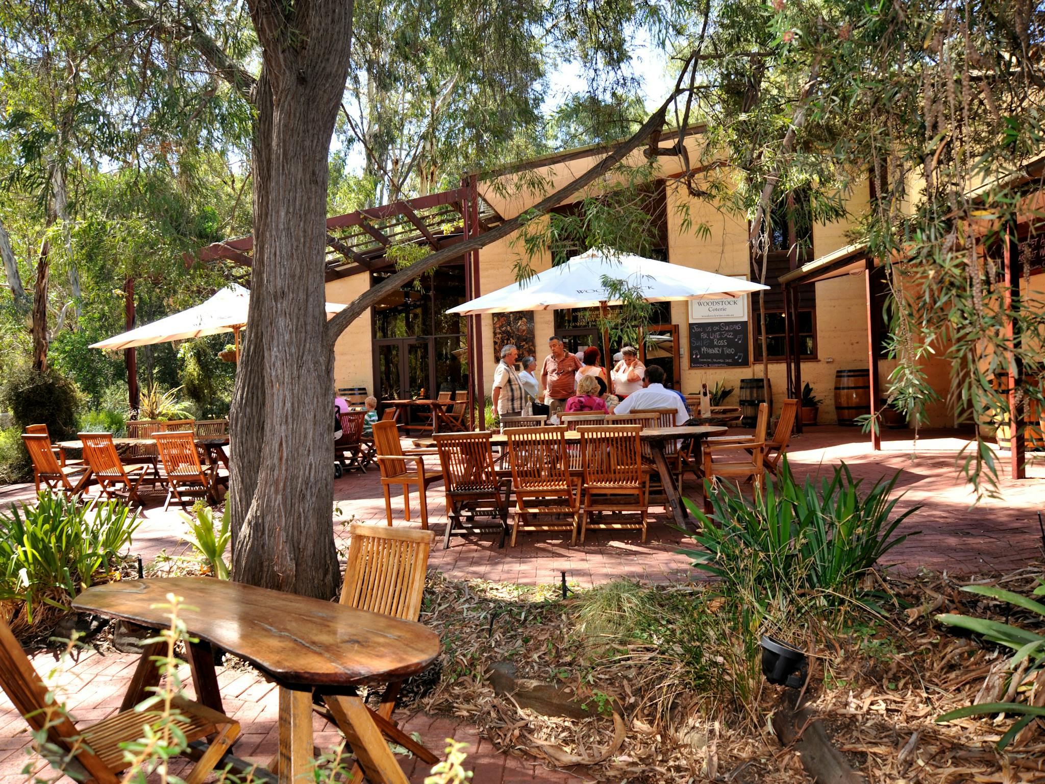 Outdoor seating area at Trilby’s Chocolates in Blewitt Springs surrounded by trees.