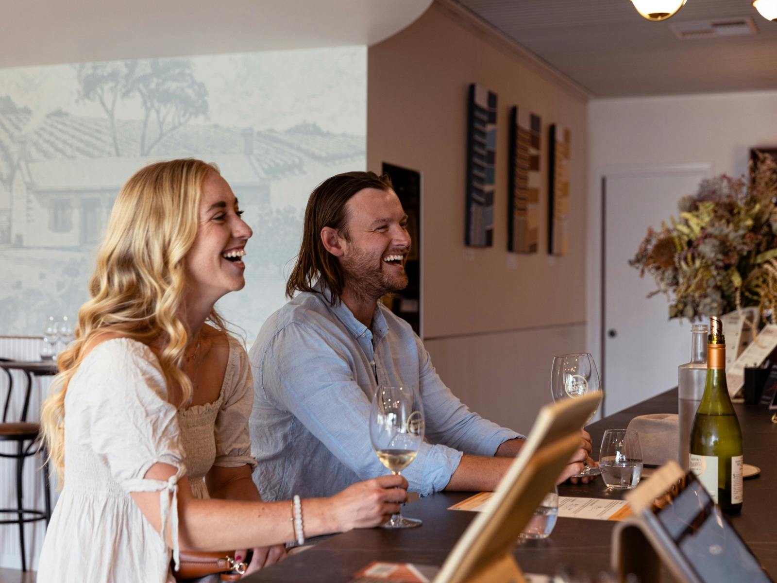 Couple laughing at bar with Oliver's Taranga host
