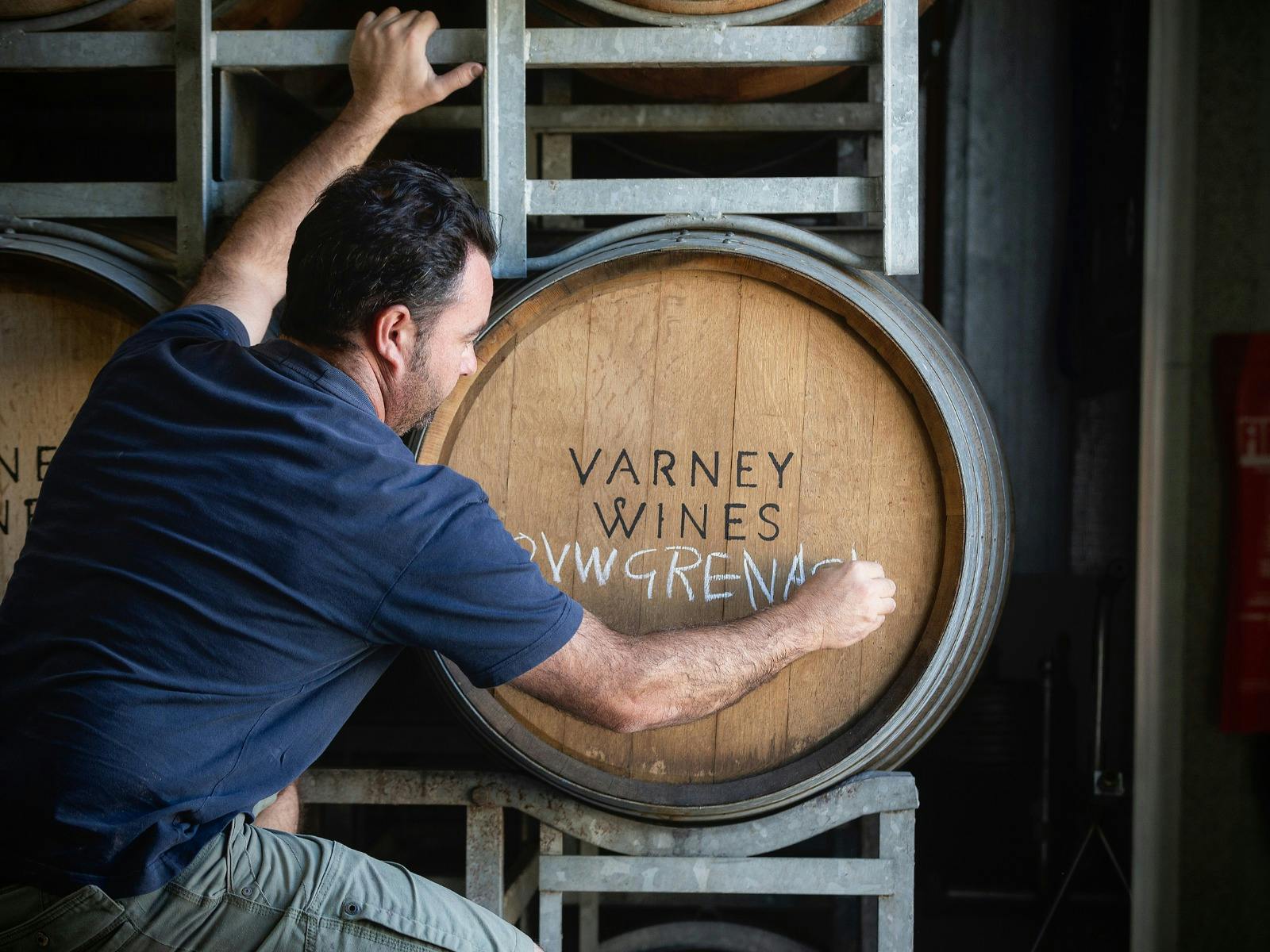 Alan Varney writing on barrels in the winery at Varney Wines