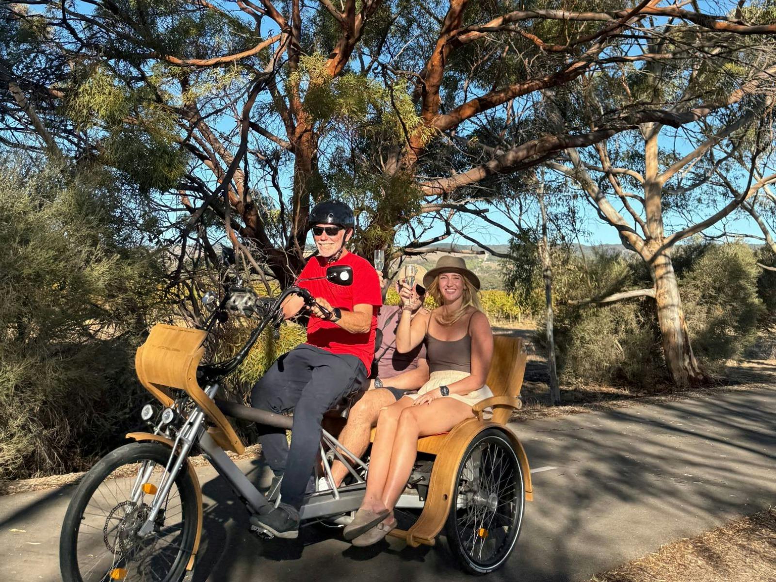 A rider and 2 passengers on a TukTuk on the Trail