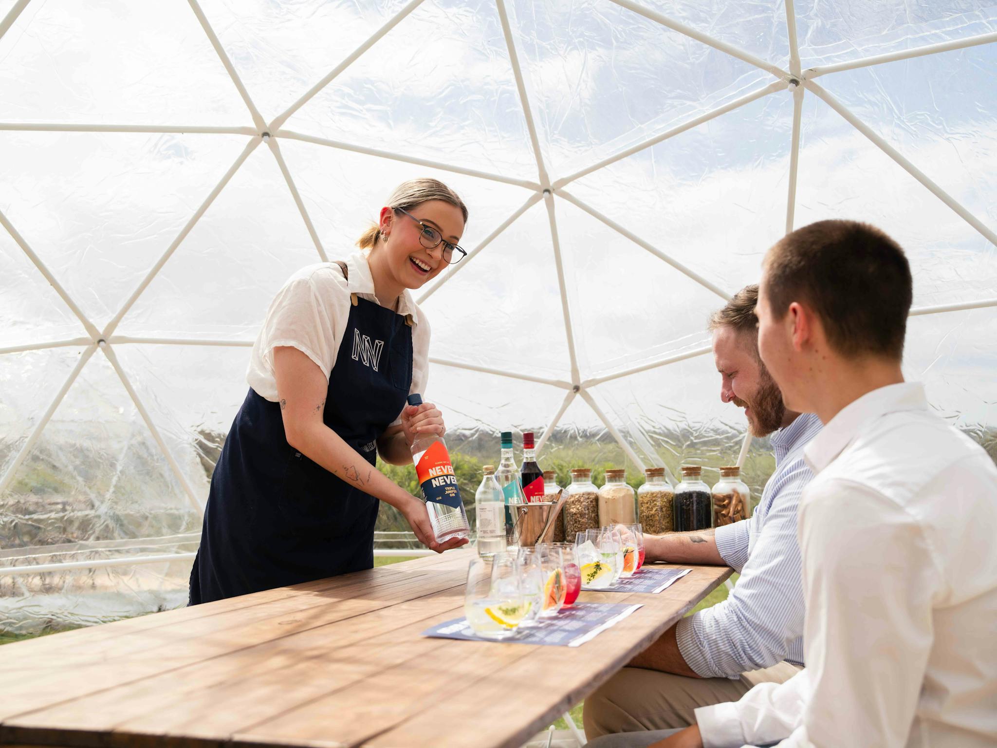 gin expert guides guests through tasting with glasses on table
