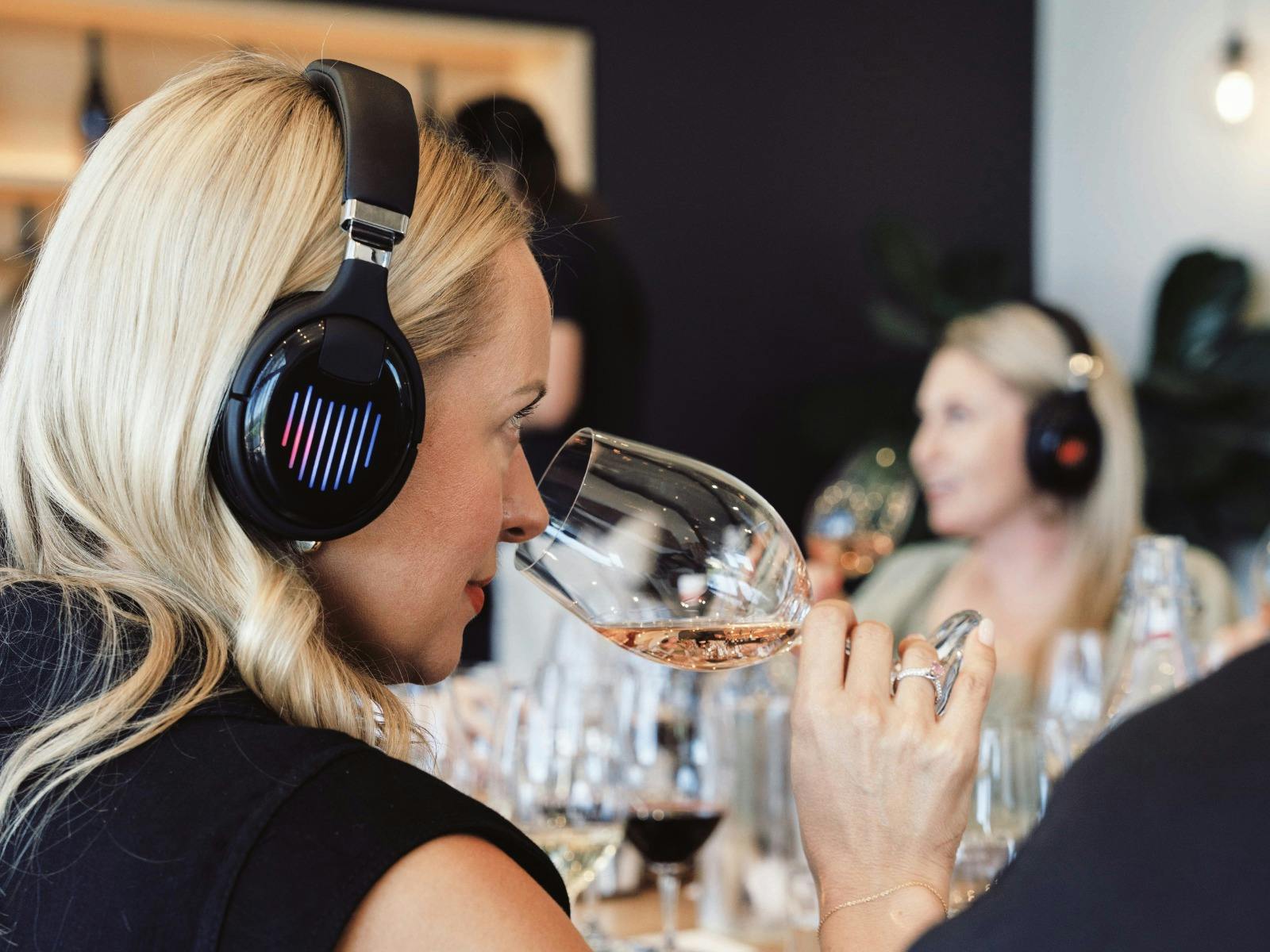 Guest smelling the wine while listening to the music through a headphone