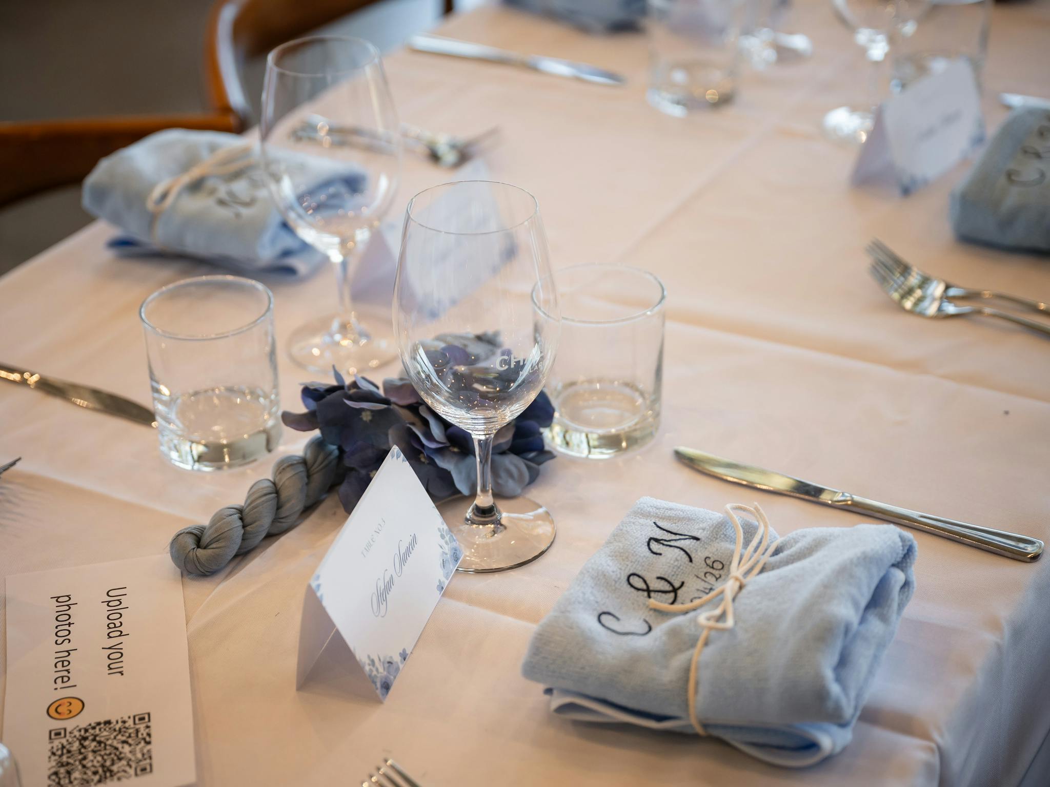 table set for a wedding reception featuring wine glass, cutlery and placeholder