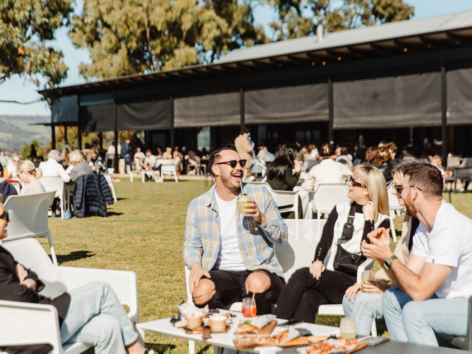Group enjoying drinks and food on lawn at OysterPalooza McLaren Vale