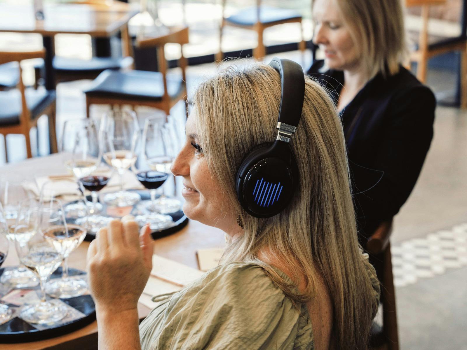 Guest smelling the wine while listening to the music through a headphone