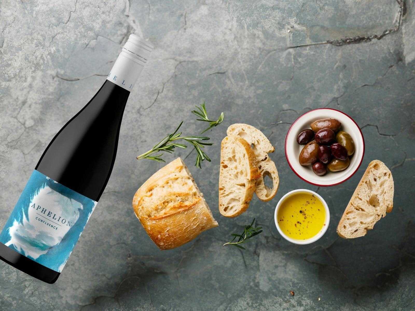 A bottle of Aphelion Confluence Grenache with Bread, Olives and olive oil