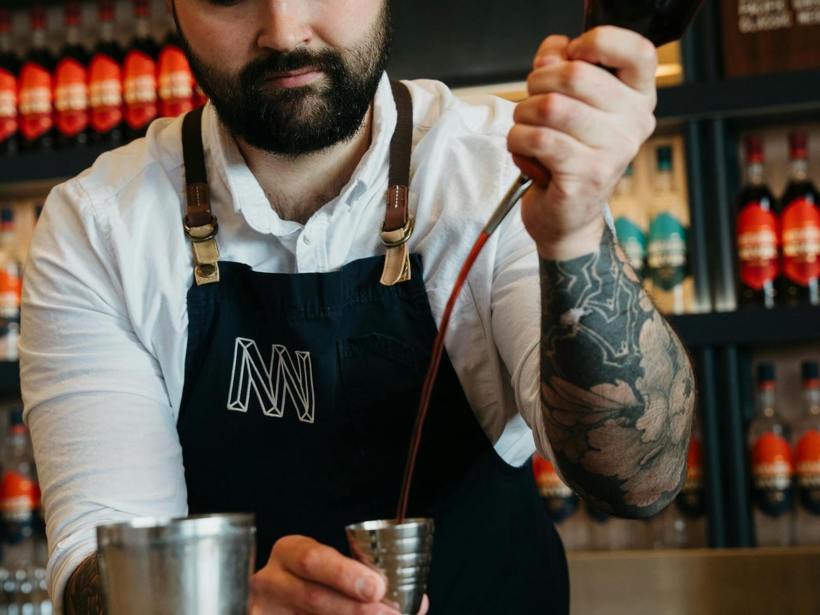 bartender pouring never never ginache into measuring cup