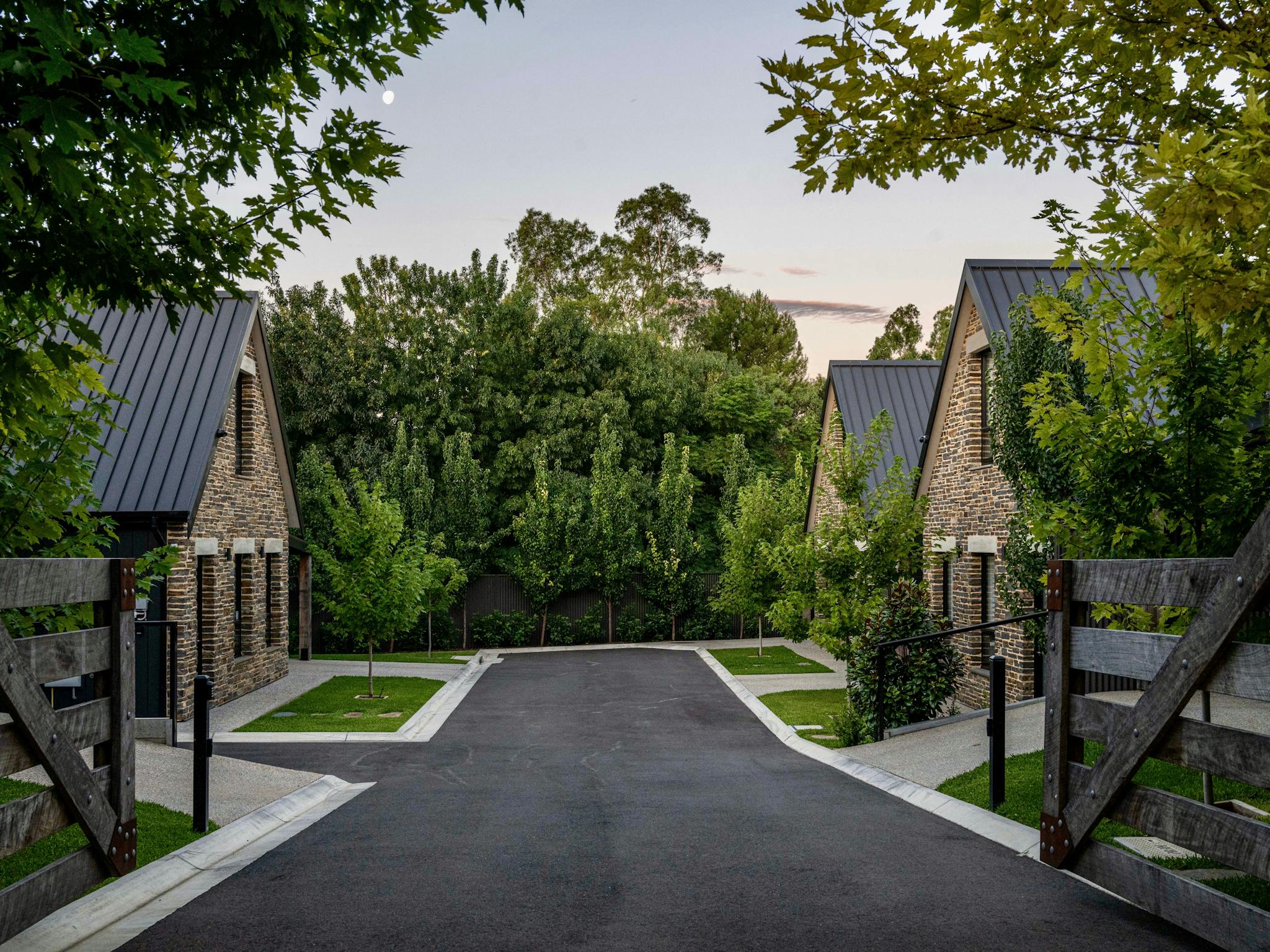 Vale 194 Entrance with stone fronted buildings and driveway with trees framing the background